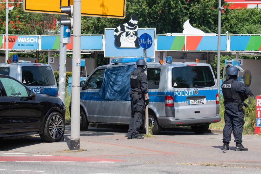 Polizisten sichern den Tatort an der Herschelstraße. In diesem schwarzen Porsche saß der Getötete.