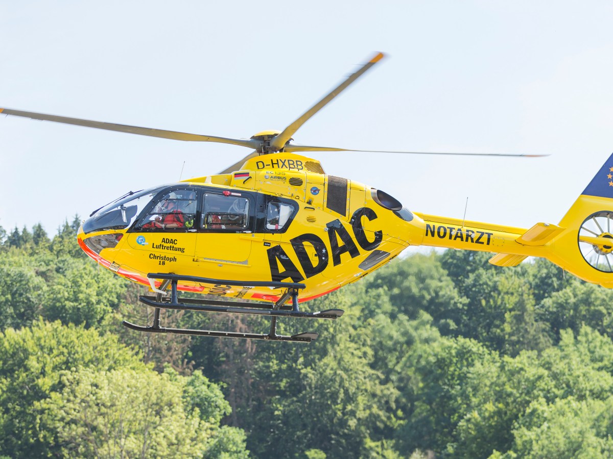 Rettungshubschrauber fliegt über Bäume