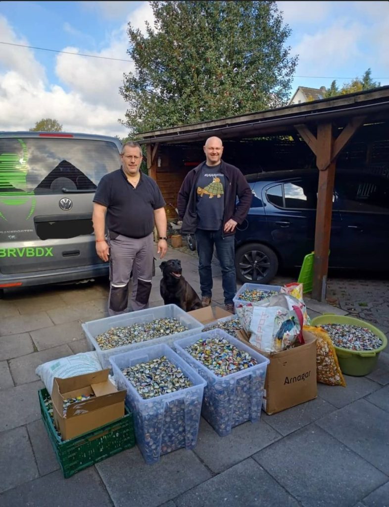 Maik (rechts) übergibt dem Pfötchen-Organisator Alexander Schmidt die gesammelten Kronkorken. 