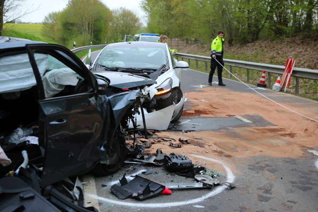 Zwei Fahrzeugwracks stehen auf der Landesstraße 569. Bei dem Unfall in der Gemeinde Gleichen im Landkreis Göttingen ist eine Frau ums Leben gekommen. Zwei Männer wurden verletzt.