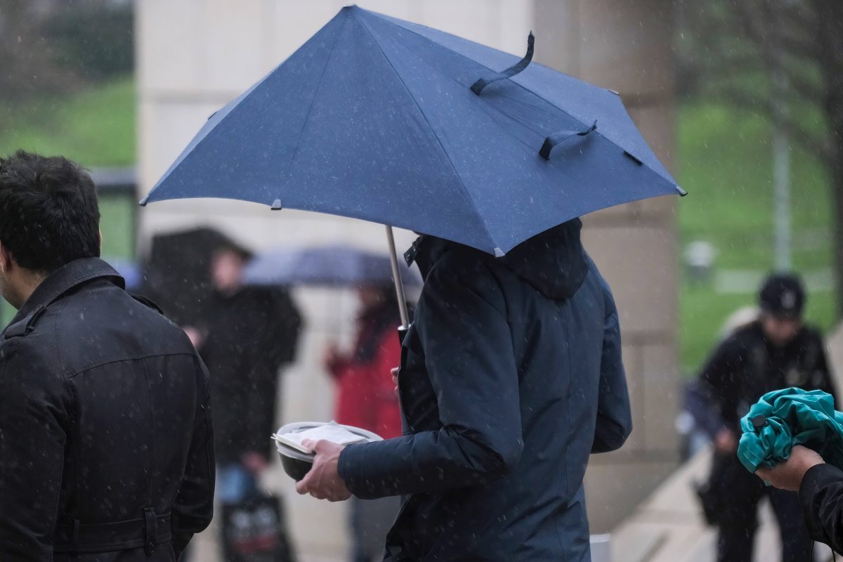 Wetter in Niedersachsen Frau geht bei Sturm mit dem Schirm durch den Regen