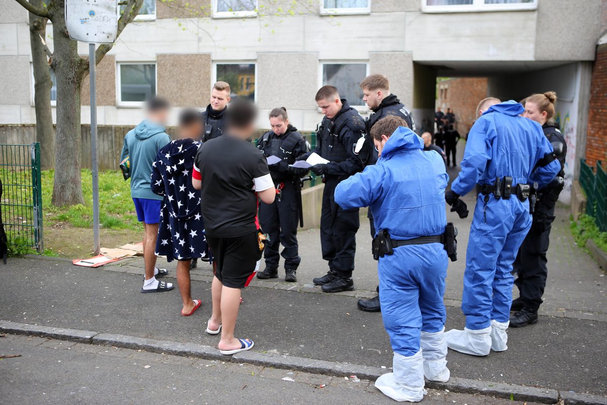 Polizisten, zum Teil in Schutzkleidung, kontrollieren Anwohner vor einem Wohnkomplex. Zahlreiche Polizisten und städtische Mitarbeiter haben am Dienstag einen Göttinger Wohnkomplex untersucht. An dem Einsatz gibt es nun Kritik.