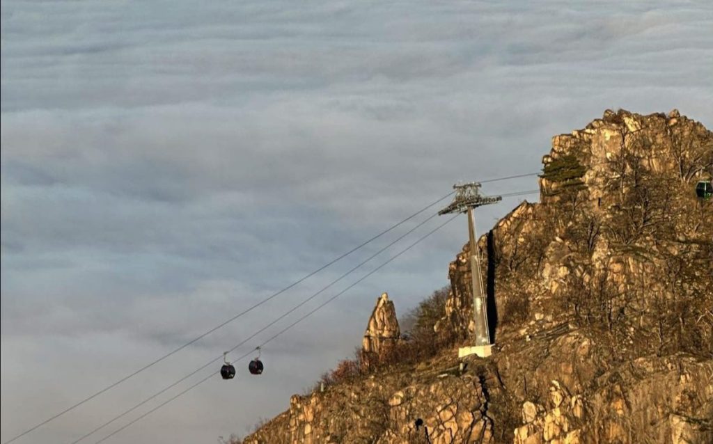 Die Lifte der Seilbahn fahren über dem Nebel im Harz entlang
