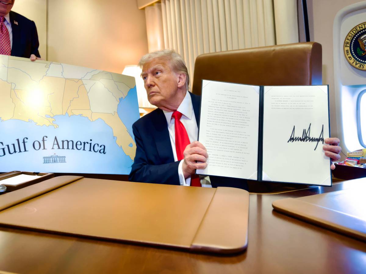 U.S. President Donald Trump, holds up the signed executive order renaming the Gulf of Mexico as the Gulf of America, during a flight on Air Force One to attend the Super Bowl,