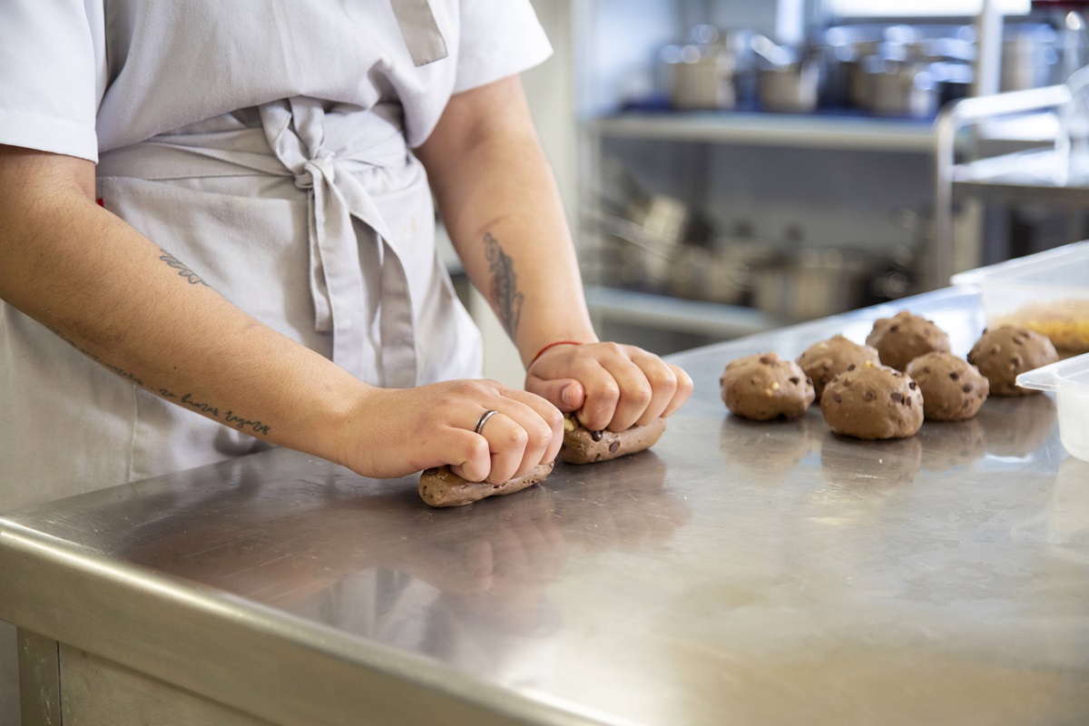 Person knetet Teig in Bäckerei