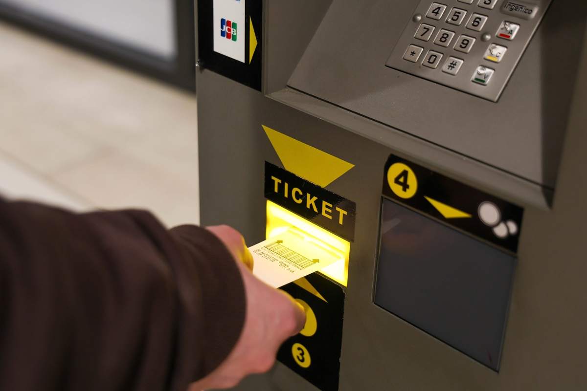 Nutzer gibt ein Parkticket in den Automaten ein, um die Parkgebühren zu begleichen.